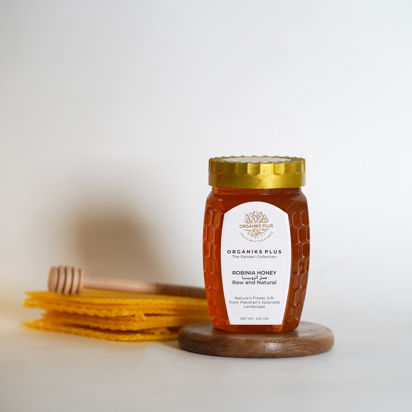 Jar of honey with a wooden lid on a white background.