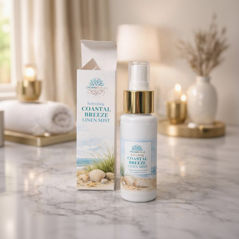 Organiks Plus Coastal Breeze linen mist bottle and packaging on a marble surface with candles in the background