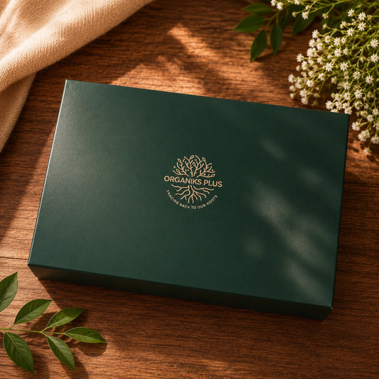 Organiks Plus Green box with 'Organiks Plus' logo on a wooden surface with leaves and flowers.
