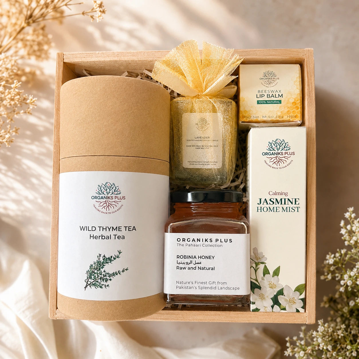Organiks Plus Gift set with tea, honey, and other products in a wooden box with a soft background.