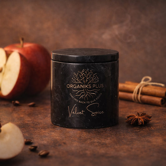 Black jar labeled 'Organiks Plus Velvet Spice' on a rustic surface with apples and cinnamon sticks.