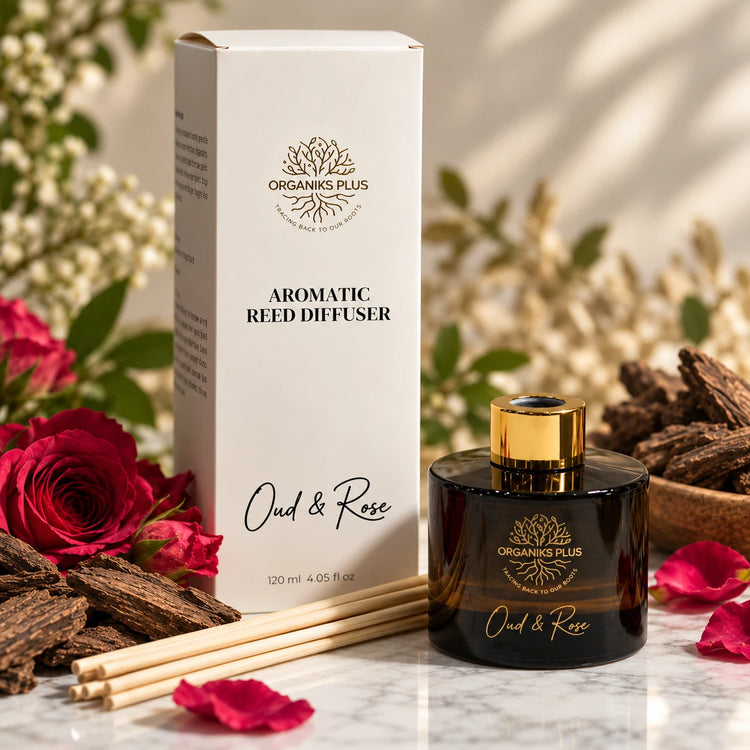 Organiks Plus Oud & Rose reed diffuser 120 ml, dark bottle with gold ring beside its presentation box and reed sticks