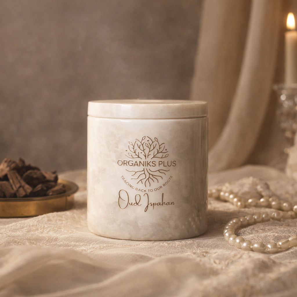 Marble container with 'Organiks Plus' branding on a textured surface with candles and pearls.